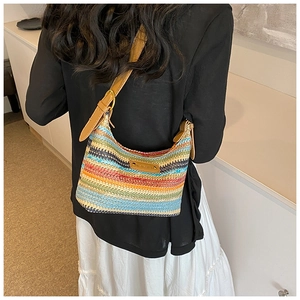 Gros plan détaillé d'un sac bandoulière tissé coloré avec un écusson logo en cuir