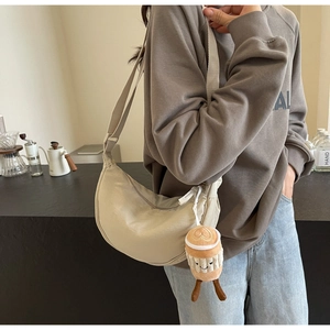Detail of beige crescent moon crossbody bag with cute coffee cup plush charm