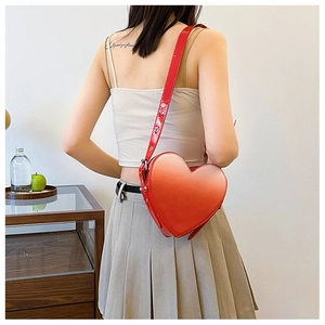 Détail du sac à bandoulière en forme de cœur dégradé rouge et orange en cuir verni brillant