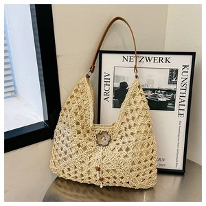 Handwoven straw tote bag with brown leather straps and floral wood buckle detail