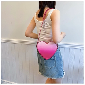 Détail d'un sac bandoulière en similicuir en forme de cœur avec dégradé rose