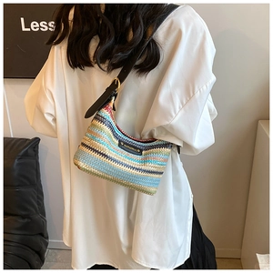 Détail du sac à bandoulière tissé coloré avec rayures texturées et lanière en cuir noir