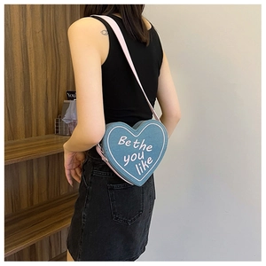 Détail du sac bandoulière en denim en forme de cœur avec broderie Be the you like