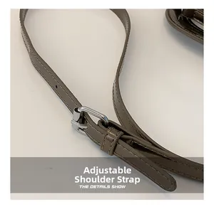Détail de la bandoulière réglable avec boucle argentée sur sac en PU marron
