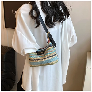 Détail d'un sac à bandoulière en paille à rayures colorées avec sangle en cuir ajustable