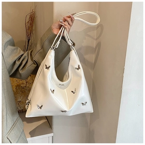 Dettaglio della borsa Hobo in pelle verniciata bianca con farfalle decorative in metallo argento