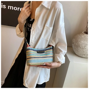 Détail du sac bandoulière en raphia tissé coloré avec rayures et écusson en cuir