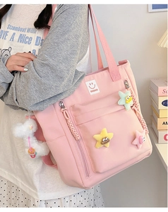 Detail of pink nylon tote bag featuring 3D colorful stars and cute plush lamb charm