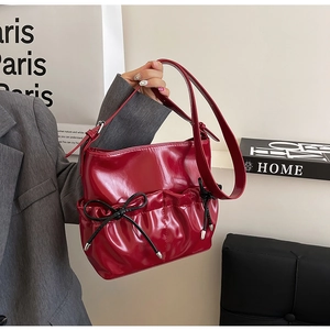 Chic red patent PU leather shoulder bag with decorative black bows and silver hardware