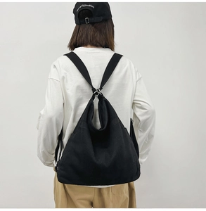 Rear view of a black canvas backpack featuring adjustable straps and durable fabric