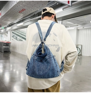 Detail view of washed denim backpack on model back in a daily casual setting