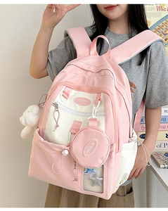 Close-up of pink and white nylon backpack with cute bear pendant and functional pockets