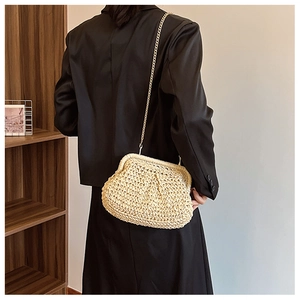 Détail du sac coquillage en paille tissée main avec chaîne dorée pour vacances à la mer