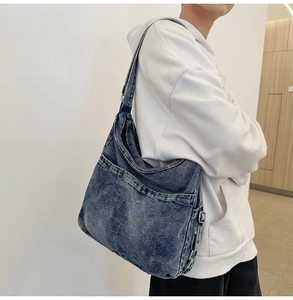 Detail van vintage blauw gewassen denim draagtas met verstelbare metalen gespriem