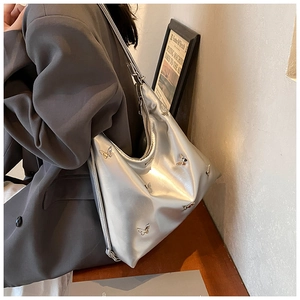 Dettaglio borsa a spalla argento metallizzato con farfalle 3D e chiusura a zip