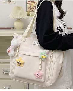 Detail of off-white nylon tote bag with colorful star charms and DDXBAGS logo patch