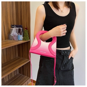 Sac à main chic en cuir PU dégradé rose avec poignée découpée porté par un mannequin