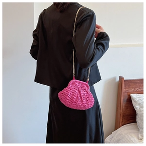 Détail du sac coquillage en paille tressée rose avec bandoulière chaîne dorée