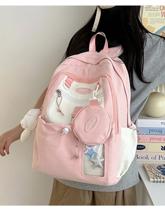 Pink and beige nylon backpack detail with star charm and plush bear accessory