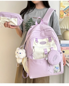 Detailed close-up of nylon backpack three-piece set with plush cat charm in cozy room