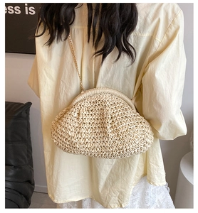 Detail of hand-woven straw cloud bag with elegant gold chain strap for summer style