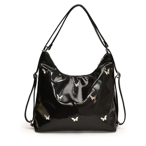 Borsa hobo minimalista in pelle PU nera lucida con ciondoli a farfalla in argento su sfondo bianco