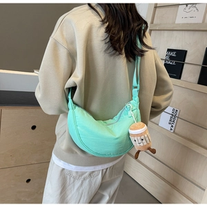 Detail of mint green crescent bag with pleat texture and cute coffee cup plush charm