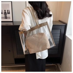 Detail view of the clear PVC tote bag with beige inner pouch and woven texture handles