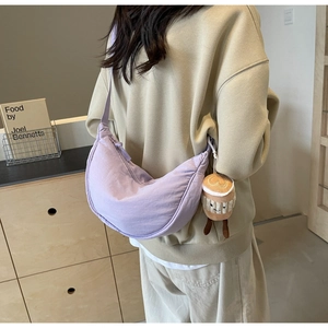 Detail of light purple crescent bag with a cute brown coffee cup plush charm on the side
