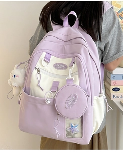Detail of lavender nylon backpack with cute white rabbit plush charm and accessories