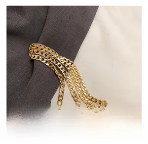 Close-up of golden flat Cuban link chain strap on a woven summer crossbody bag detail