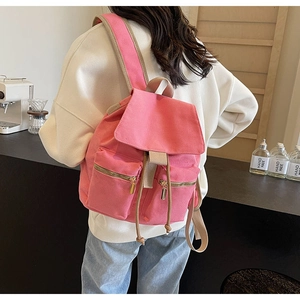 Mochila de lona rosa con cierre de cordón y dos bolsillos con cremallera en modelo