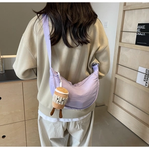 Detail of lavender crescent crossbody bag with cute plush coffee cup charm on shoulder strap