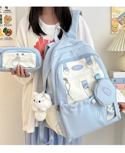 Detail of light blue nylon backpack set with multiple pockets and cute cat pendant