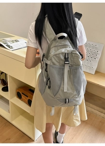 Detailed view of the nylon backpack showing adjustable buckles and breathable mesh pocket