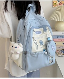 Detail of blue and beige nylon backpack with cute cat plush charm and round coin purse