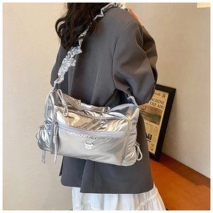 Detail of silver metallic nylon crossbody bag with ruffled strap and drawstring design