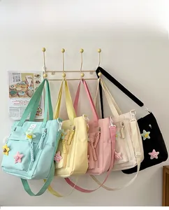 Detail view of colorful nylon tote bags with star charms and adjustable straps in five colors