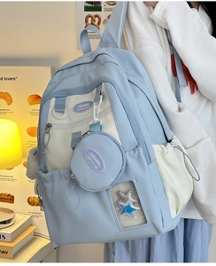 Detail of blue and white nylon backpack featuring a clear star window and small round pouch