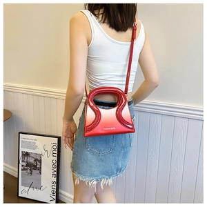 Vue détaillée du sac bandoulière rouge dégradé en similicuir avec poignée ondulée