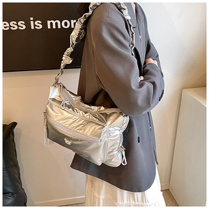 Detail of silver metallic PU shoulder bag featuring ruffled straps and a cute bear buckle