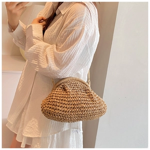 Macro detail showing woven straw texture and gold chain on the summer crossbody cloud bag