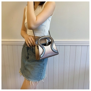 Détail du mini sac bandoulière dégradé avec une poignée découpée au design unique