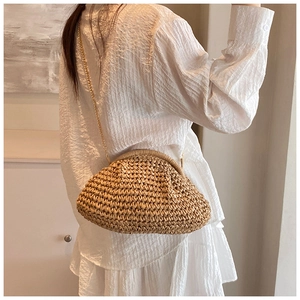 Detailed close-up of handmade straw cloud bag with elegant gold chain strap and woven texture
