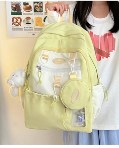Detail of a nylon backpack featuring buckle straps, plush charm, and a small round pouch