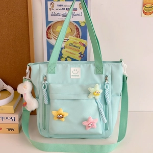 Mint green nylon shoulder bag with cute plush charms and smiley logo for daily use