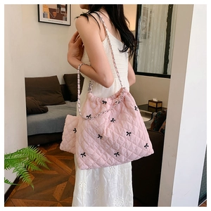 Pink quilted tote bag with black bow embroidery and silver chain strap detail