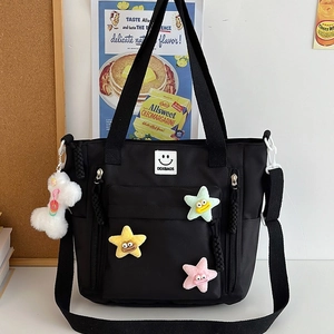 Fashionable black nylon tote bag with colorful plush stars and bone charm accessory