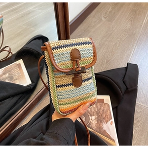 Summer straw crossbody bag with colorful stripes, brown leather trim, and horn buckle closure