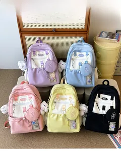 Detail of five colorful nylon backpacks with star transparent pockets and plush pendants
